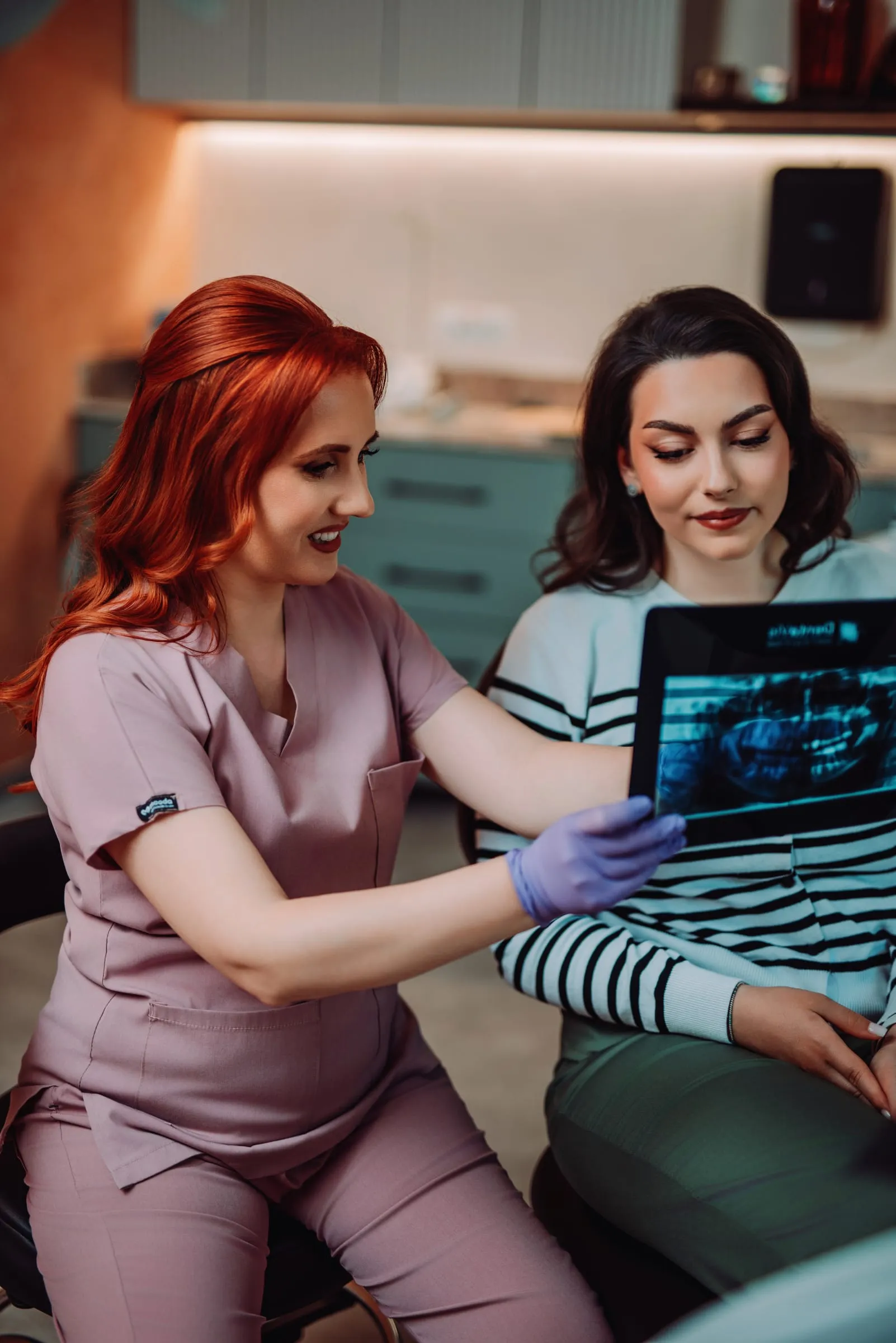Medic Cocard explicând unei paciente o radiografie dentară pe tabletă