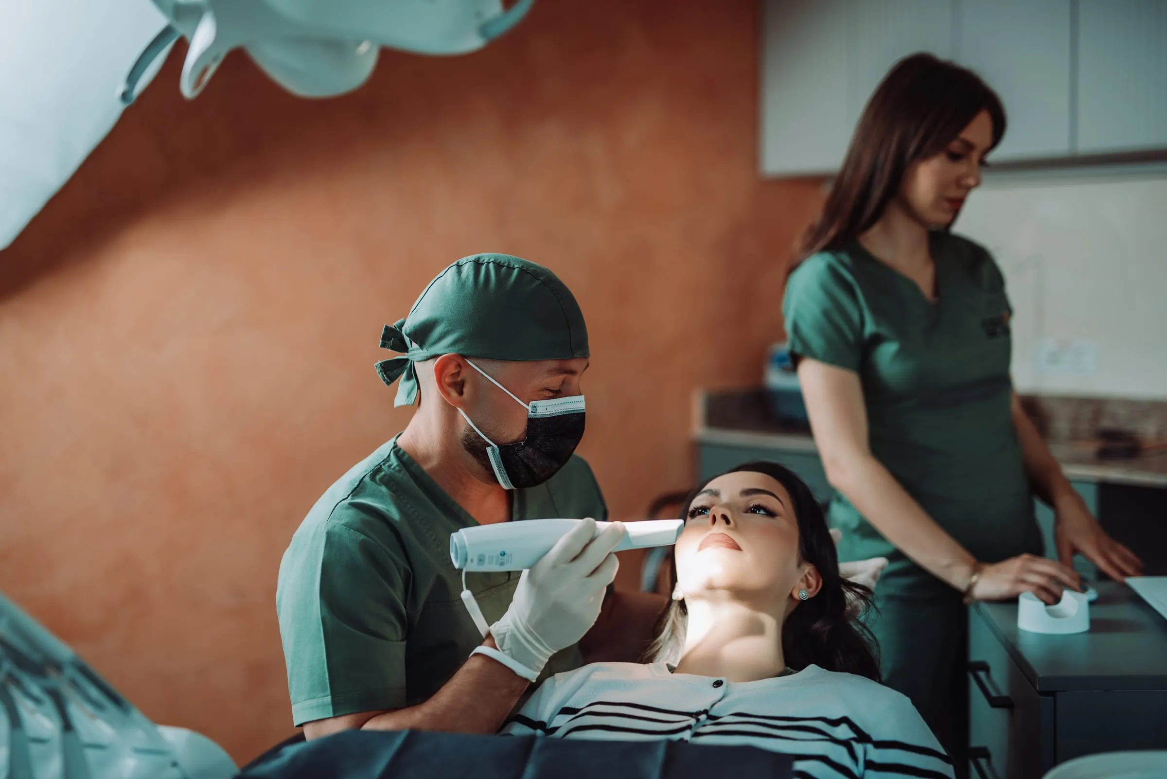 Medic stomatolog Cocard consultând o pacientă în cabinet